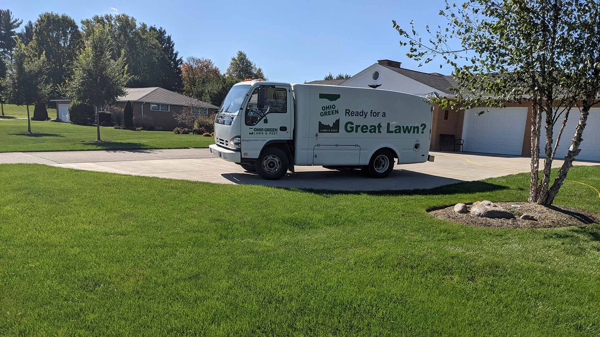 Bellville, OH home with deep, thick grass next to a lawn care service truck.